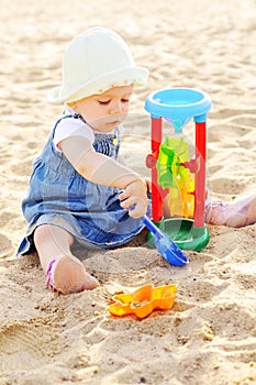 Toddler girl playing Â toys in sand